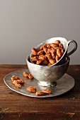 Roasted almonds in a silver cup on a plate