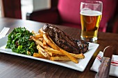 Dry-aged New York strip steak with fries and green kale salad