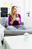 Frau mit Teetasse auf dem Sofa