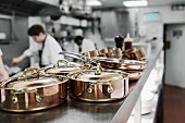 Kupfertöpfe in der Restaurantküche, Köche bei der Arbeit