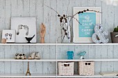 Baby's footprints, booties, framed motto and ornaments on shelves on exposed concrete wall