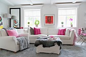 Weiß gestalteter, femininer Wohnraum mit wenigen Farbakzenten in Pink und Rot