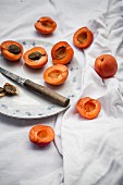 Aufgeschnittene Aprikosen auf Teller und daneben