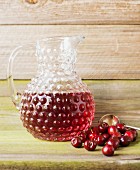 A jug of cherry juice with fresh cherries