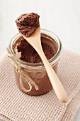 Mousse au chocolat in a jar with a wooden spoon