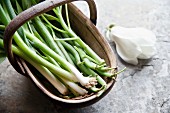 Spring onions and green beans in a wooden basket