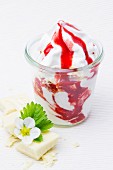 Frozen yogurt with strawberry sauce, white chocolate and a strawberry flower