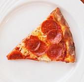 Ein Stück Pizza mit Peperoniwurst