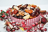 A Christmas cake decorated with dried fruits, walnuts, almonds and icing sugar