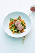 Pork fillet on a bed of colourful vegetables