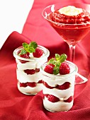 A raspberry and cream layered dessert and a strawberry and sour cherry smoothie