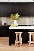 Kitchen with brown cupboards & island counter with wooden stools