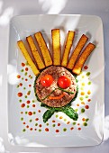 A funny face made from minced meat and polenta sticks