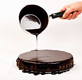 Chocolate glaze being poured over a Sachertorte