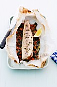 Char fillet with tomatoes in parchment paper