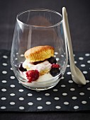 A cupcake in a glass with cream cheese and berries