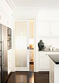 Contemporary fitted kitchen with white, coffered doors and dark parquet floor