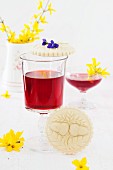 Springerle (anise biscuits with an embossed design) with spring flowers and strawberry wine