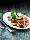 Beef steak with root vegetables, tomatoes and prunes