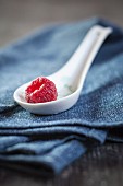 A raspberry on a porcelain spoon
