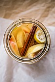 Apfelkompott mit Zimtstange, Zitrone und Gewürznelken im Einmachglas