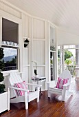 White wooden chairs with striped cushions on veranda of Colonial-style country house