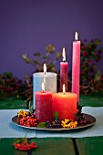 Zinnteller mit Kerzen & verschiedenfarbigen Herbstbeeren dekoriert