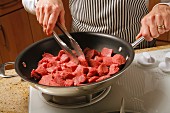 Diced sirloin beef being fried in a pan