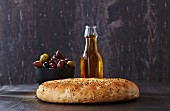Unleavened bread, olives and a bottle of olive oil
