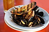 Mussels in a beer broth with garlic and herbs served with grilled bread