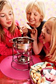 Children eating chocolate fondue