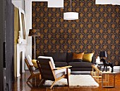 Wohnzimmer mit dunklem Sofa, Sesseln im Fiftiesstil und Flokati vor eleganter, dunkel gemusterter Tapete