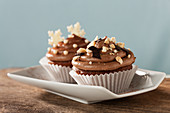 Cupcakes topped with chocolate cream and nuts for Christmas