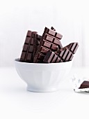 Bars of chocolate in a white ceramic bowl