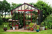 Planters in and around greenhouse in rural setting