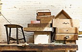 Verschiedene alte Holz Schubladen auf Werkbank gestapelt vor geweisselter Ziegelwand