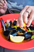 Mussels being drizzled with lemon juice