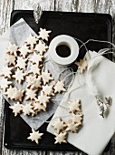 Cinnamon stars on a baking tray with silver bird figures
