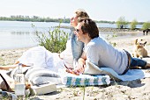 Couple and dog enjoying beach picnic