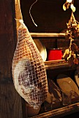 Prosciutto hanging in a kitchen cupboard