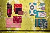 Samples of various floral fabrics in shades of red and blue on gold background