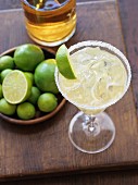 A margarita with a salted rim garnished with a wedge of lime