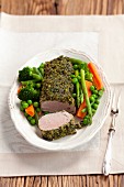 Pork loin with a parsley coating served with spring vegetables
