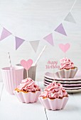 Cupcakes mit rosa Buttercreme und Wimpelkette zum Geburtstag