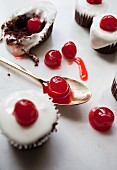 Chocolate cakes decorated with icing sugar and glace cherries