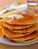 Pile of pancakes with maple syrup and butter