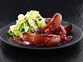 Sausages with red onion gravy and colcannon (mashed potatoes with green kale, Ireland)