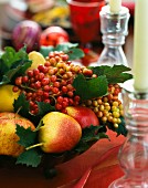 An arrangement with a large fruit bowl and a glass candle holder