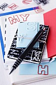 Various notebooks and letter-shaped paperclips