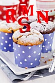 Vanilla and chocolate muffins in polka dot paper cases with red sugar letters
